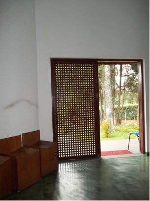 Figura 5 - Porta de madeira tipo muxarabi, bancos de madeira projeto de Lina Bo  e paginação de piso pelo vértice da parede. Foto: Autora, 2011