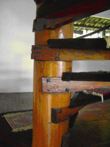 Detalhe da escada. Coluna de madeira bruta e degraus com parafusos transpassantes. Foto: Edite Galote Carranza